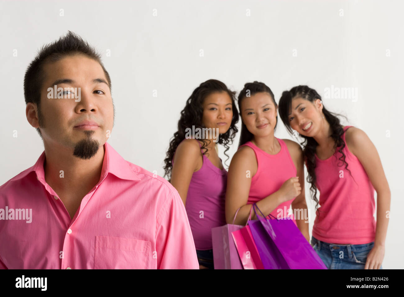 Portrait of a young man with three young women standing behind him