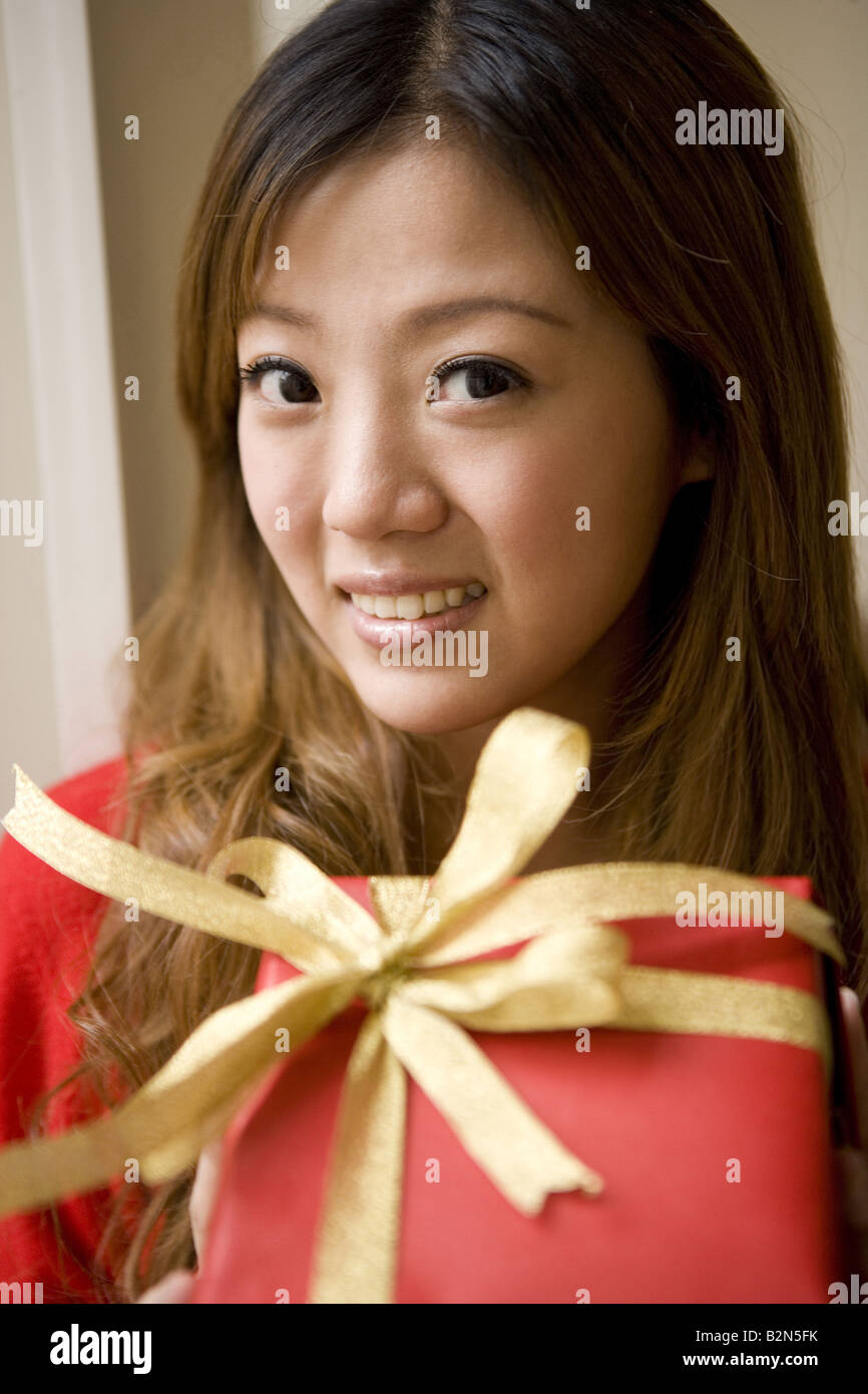 Portrait of a young woman holding gift Stock Photo - Alamy