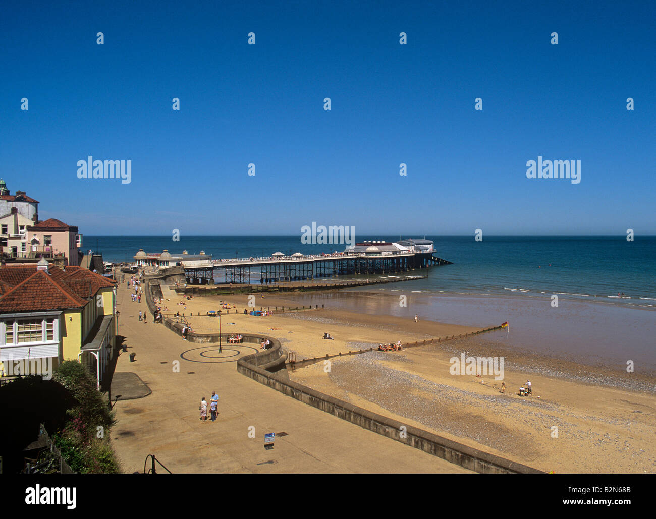 Cromer esplanade with a few visitors on the beach and the famous pier with summer theatre North Norfolk coast summer 2008 Stock Photo