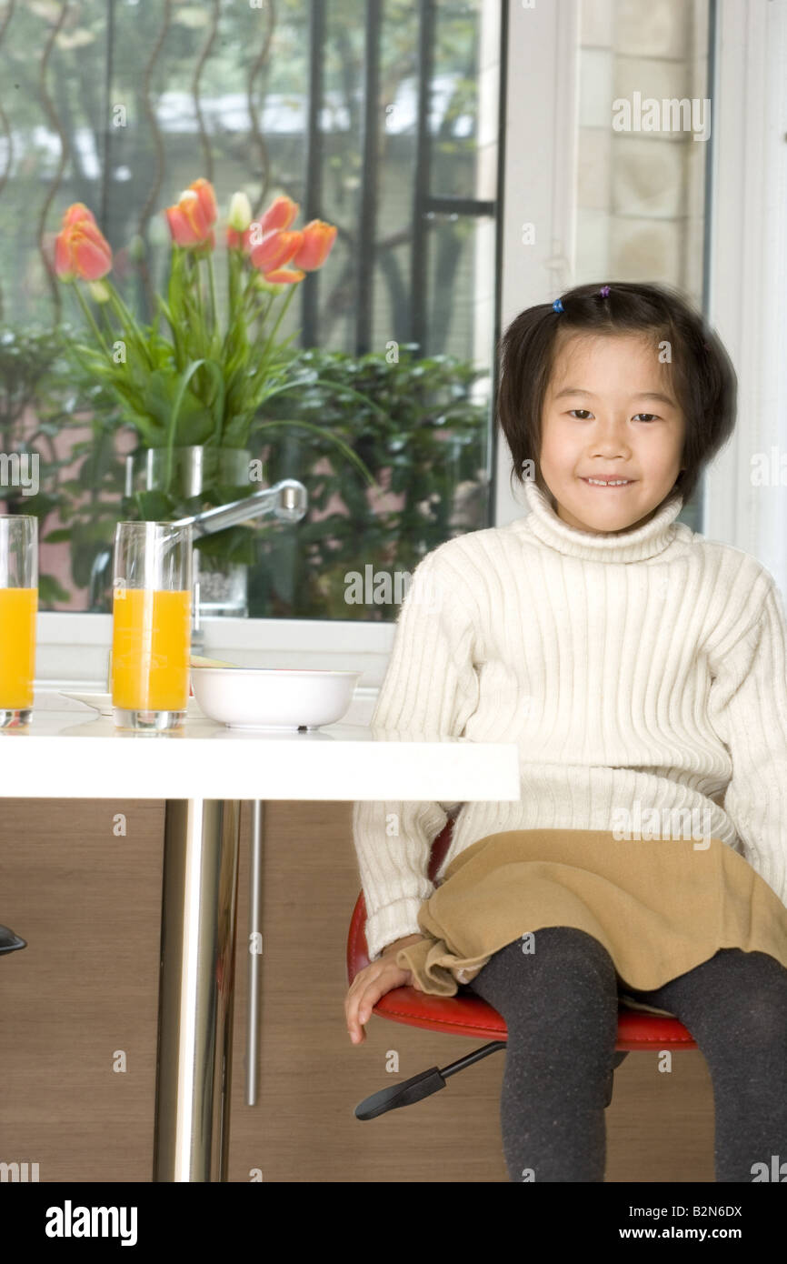 Portrait of a girl sitting at a breakfast table and smiling Stock Photo ...