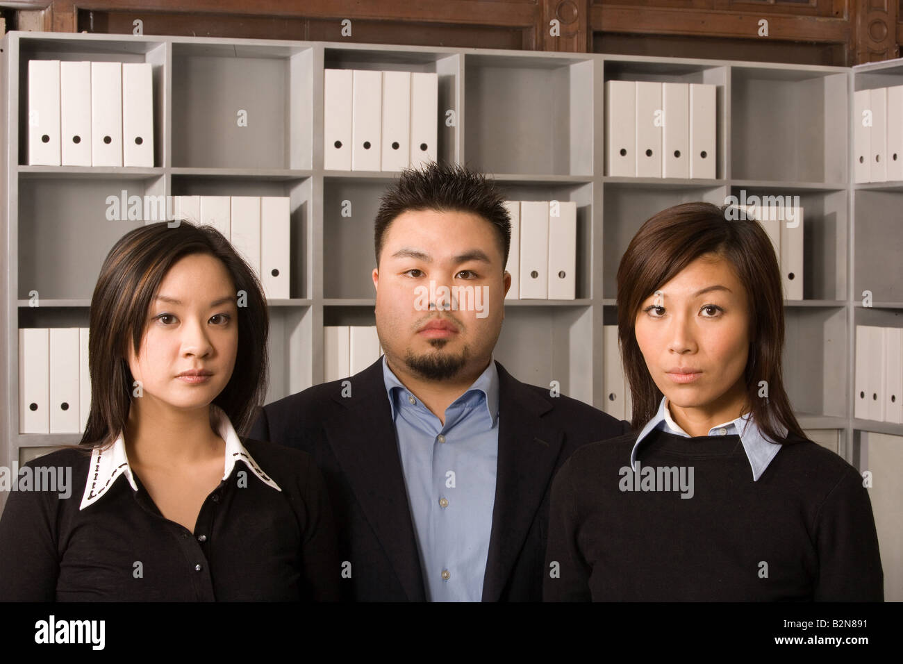 Portrait of a businessman with two businesswomen in an office Stock ...