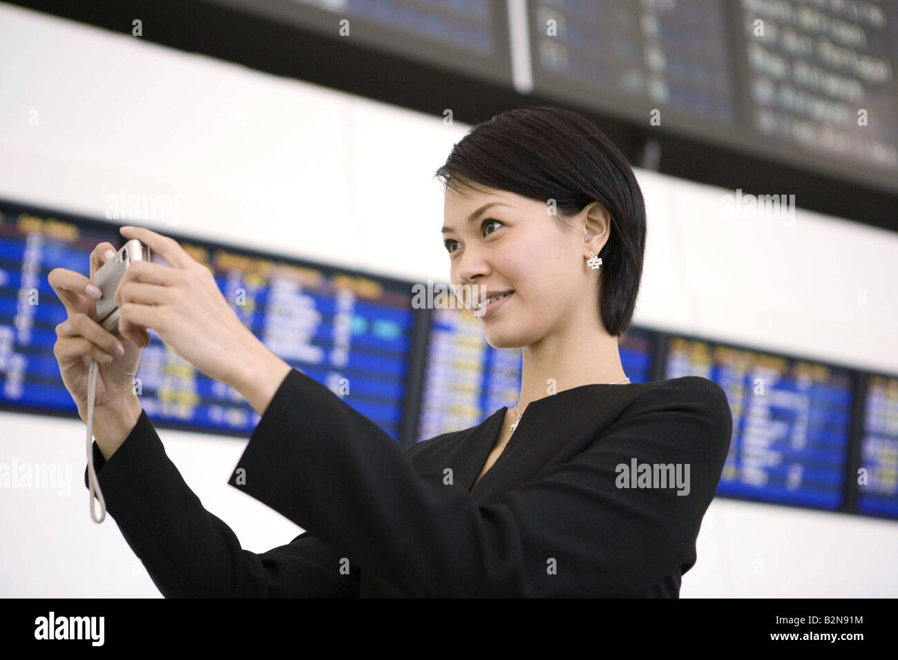 Businesswoman taking a picture at an airport Stock Photo - Alamy
