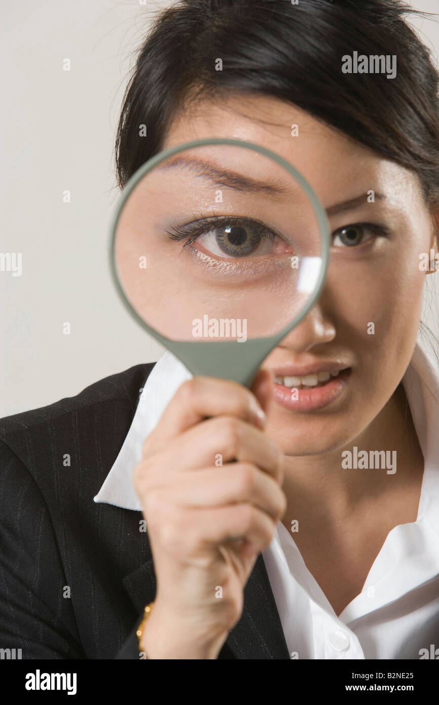 Portrait of a businesswoman looking through a magnifying glass Stock ...