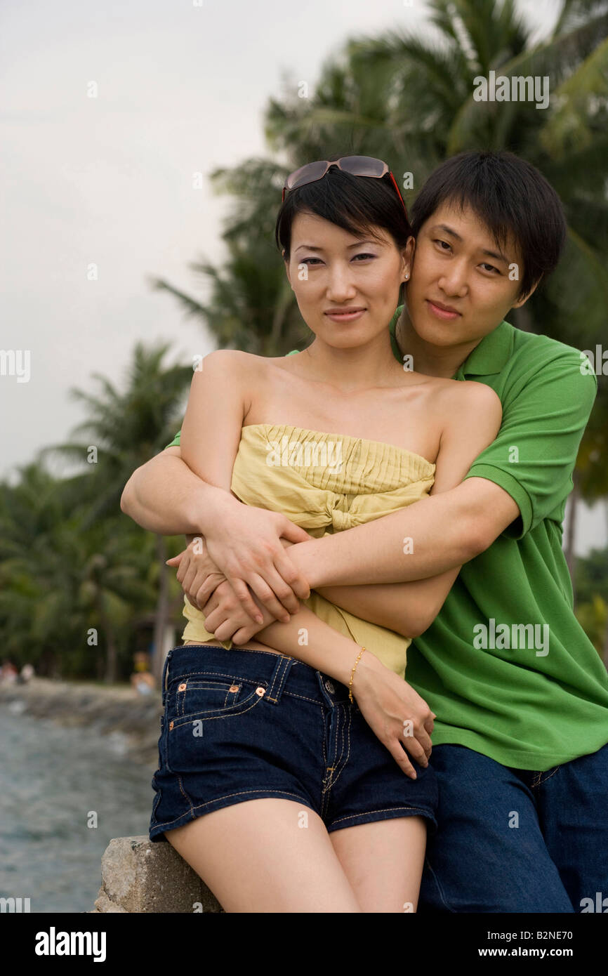 Portrait of a mid adult man embracing a mid adult woman on the beach ...