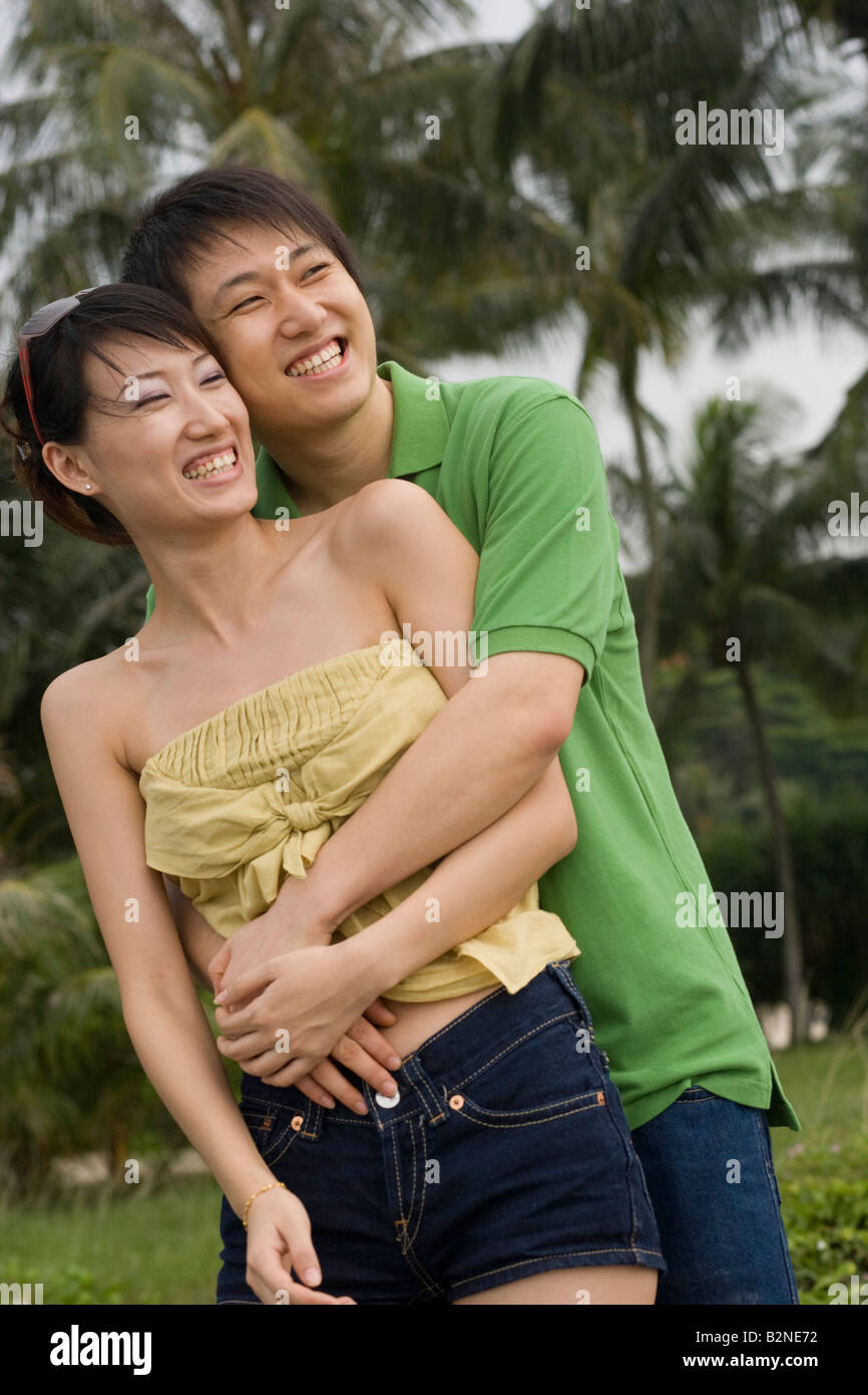 Mid adult man embracing a mid adult woman on the beach and smiling ...