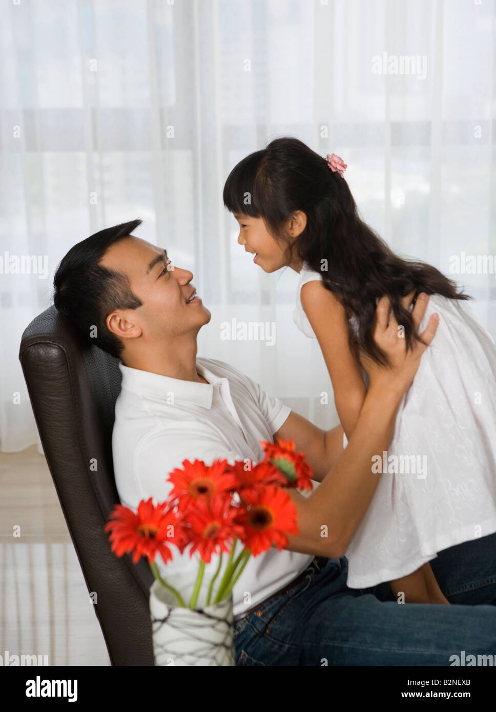 Side profile of a mid adult man sitting on chair and picking up her ...