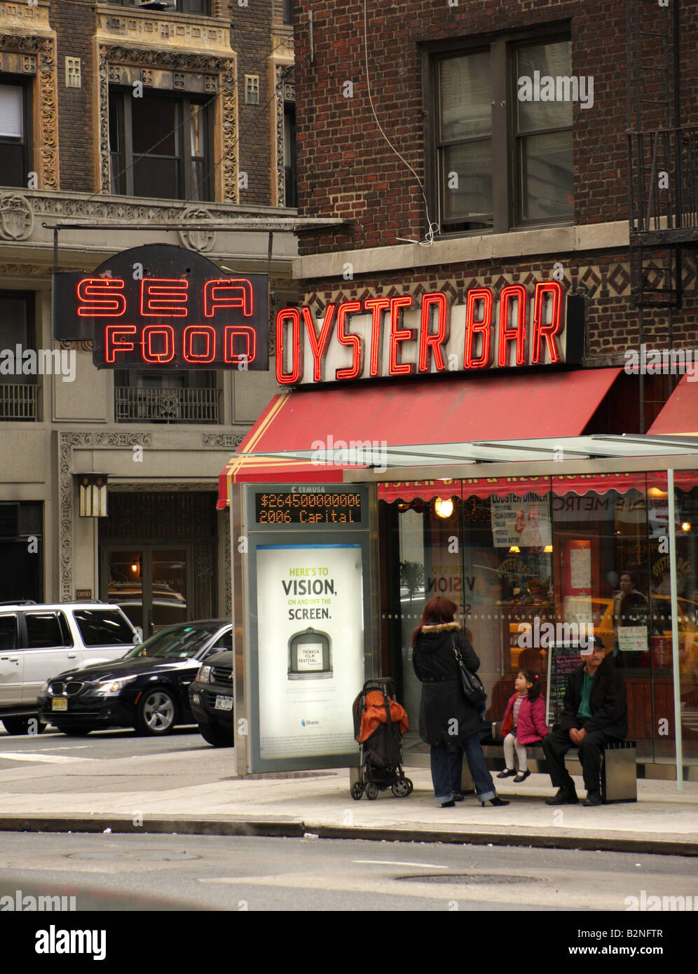 A New York bus stop with an Oyster Bar neon sign behind Stock Photo