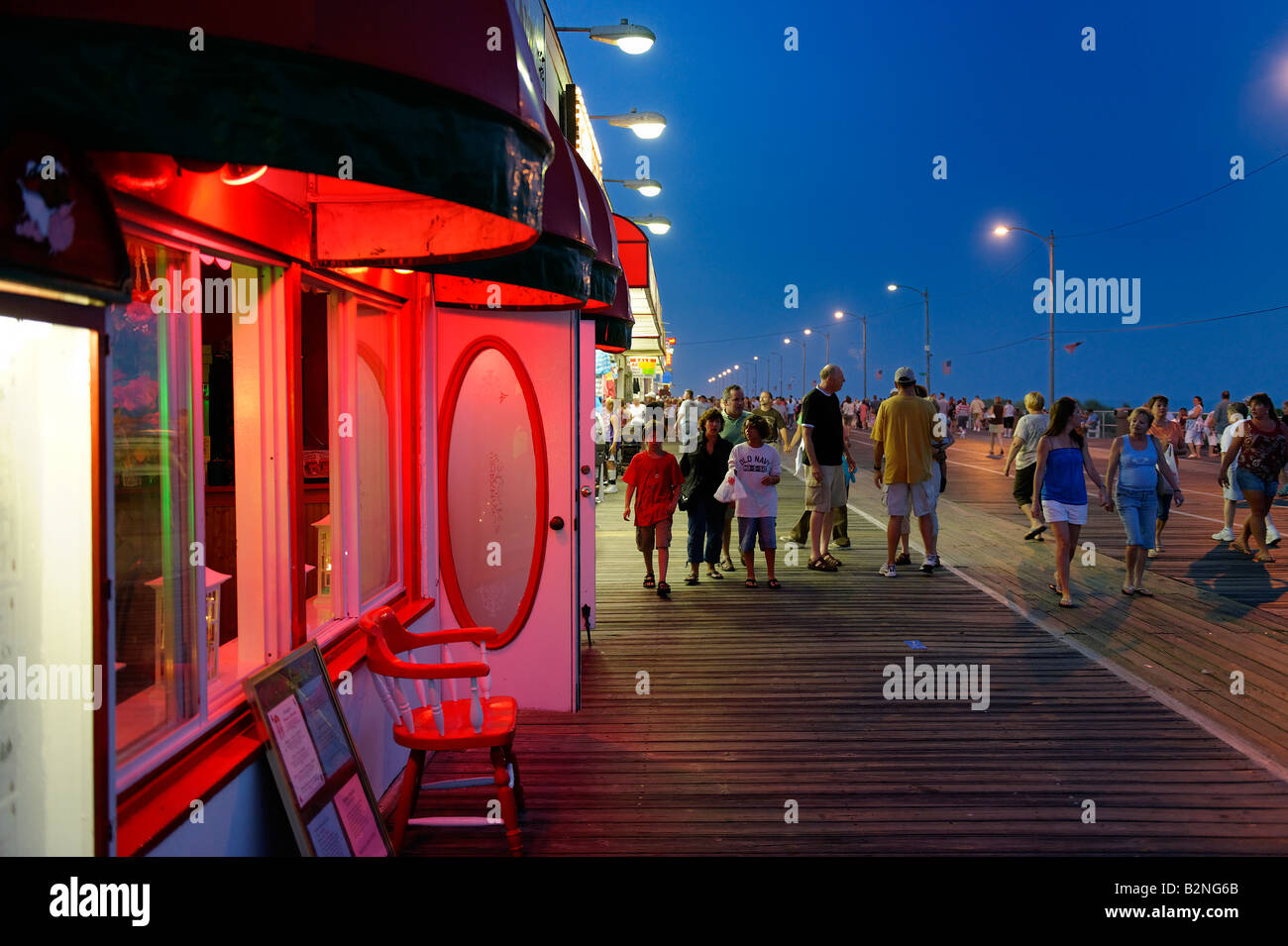 Vacationers strolling along the boardwalk at night Stock Photo