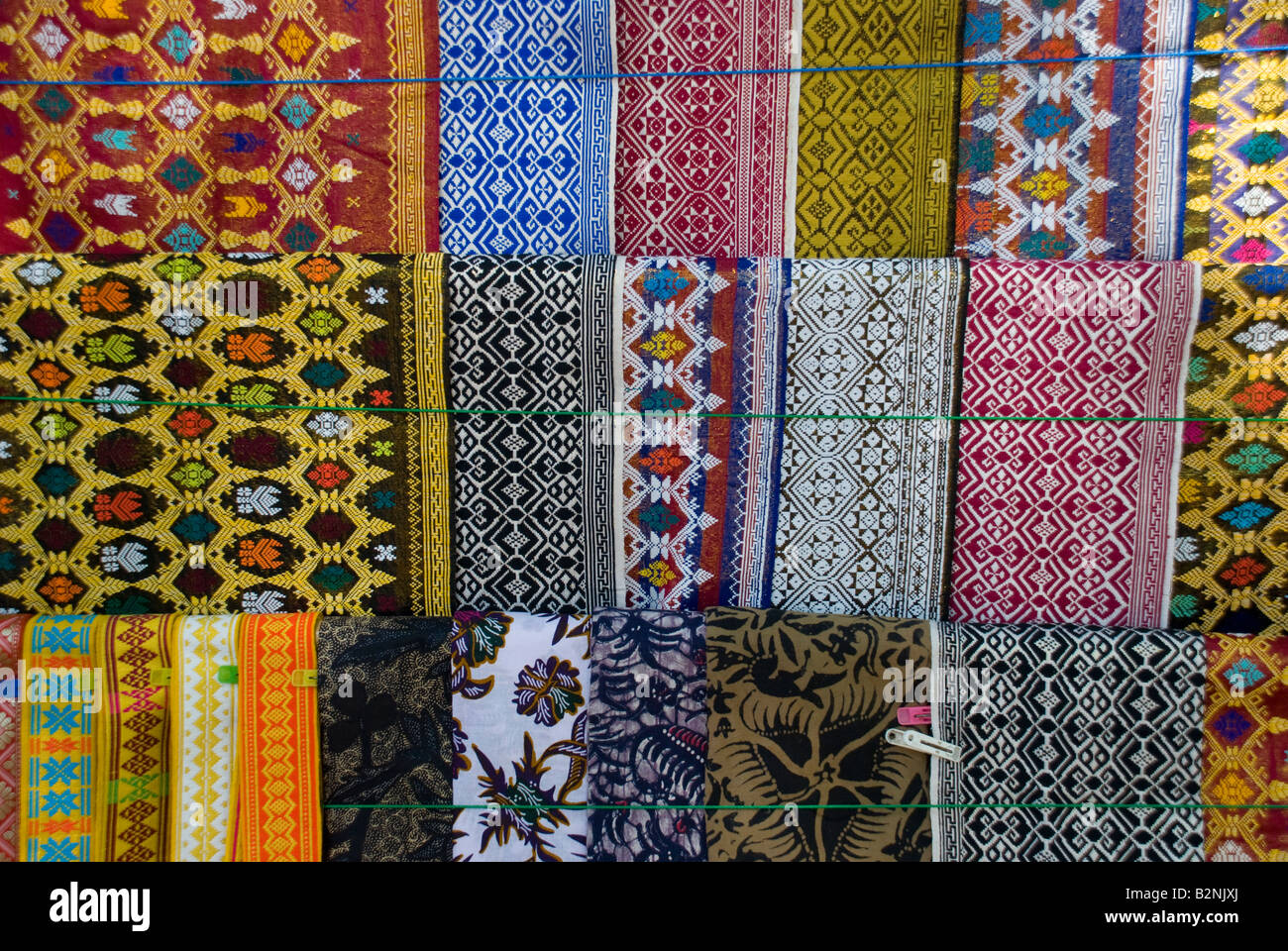 bali indonesia textiles colour sarong color pattern craft trade repeat  stall stand sell rack Stock Photo - Alamy