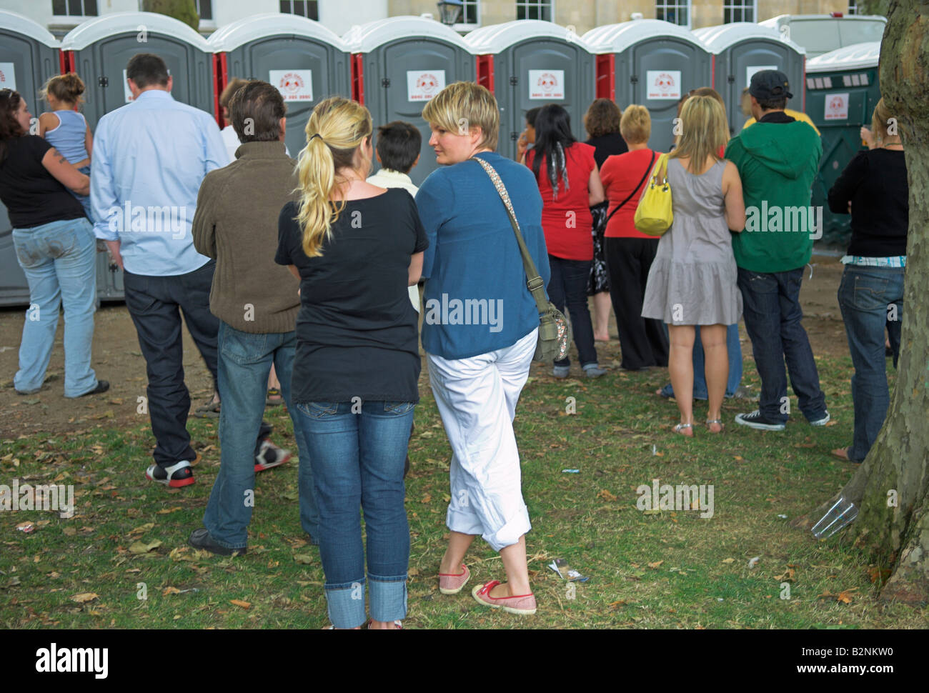 People waiting to use portable toilets Stock Photo