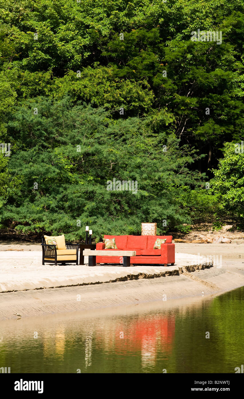 A living room suite including a couch a chair and a side table set up in natural environment next to a river Stock Photo