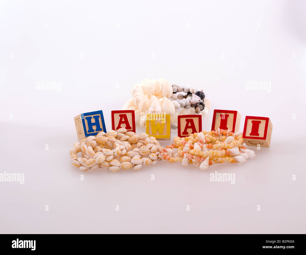 Three shell necklaces with childrens blocks spelling Hawaii Stock Photo