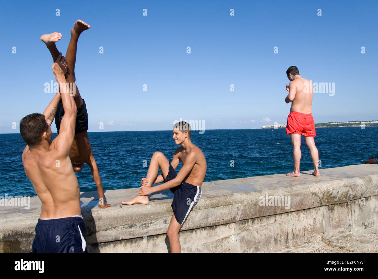 People playing on sea wall on the El Malecon in Havana Cuba Stock Photo