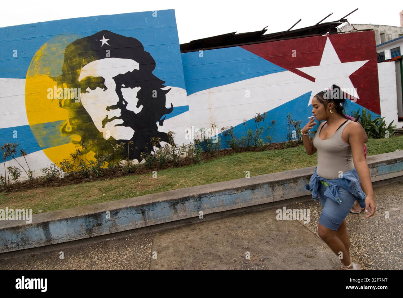 Cuban lady walking past Ernesto Che Guevara mural. Centro. Havana. Cuba Stock Photo