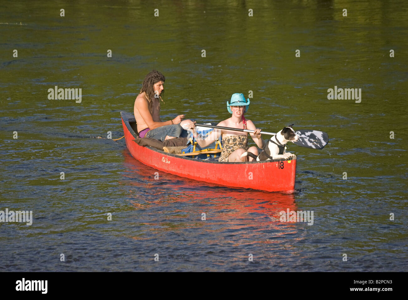Man and woman with dog paddling red Canadian canoe River Wye UK Stock