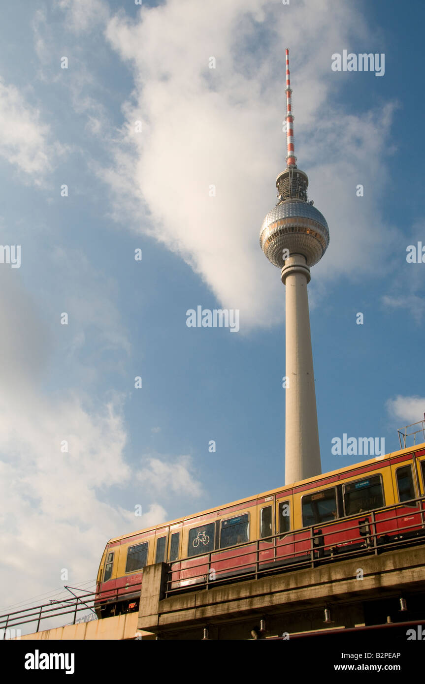 An S-Bahn train pass by the Fernsehturm communication antenna tower built in 1969 by the former German Democratic Republic (GDR) in Berlin Germany Stock Photo