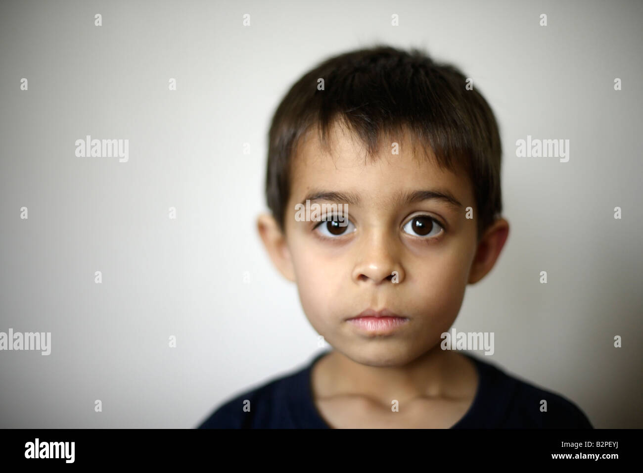 Six year old boy mixed race indian ethnic Hands of father holding his face Stock Photo