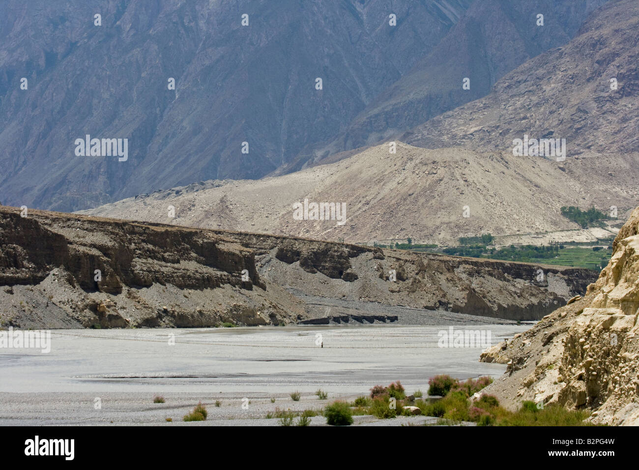 Hunza Man Walking on Suspension Bridge in Passu Northern Pakistan Stock Photo