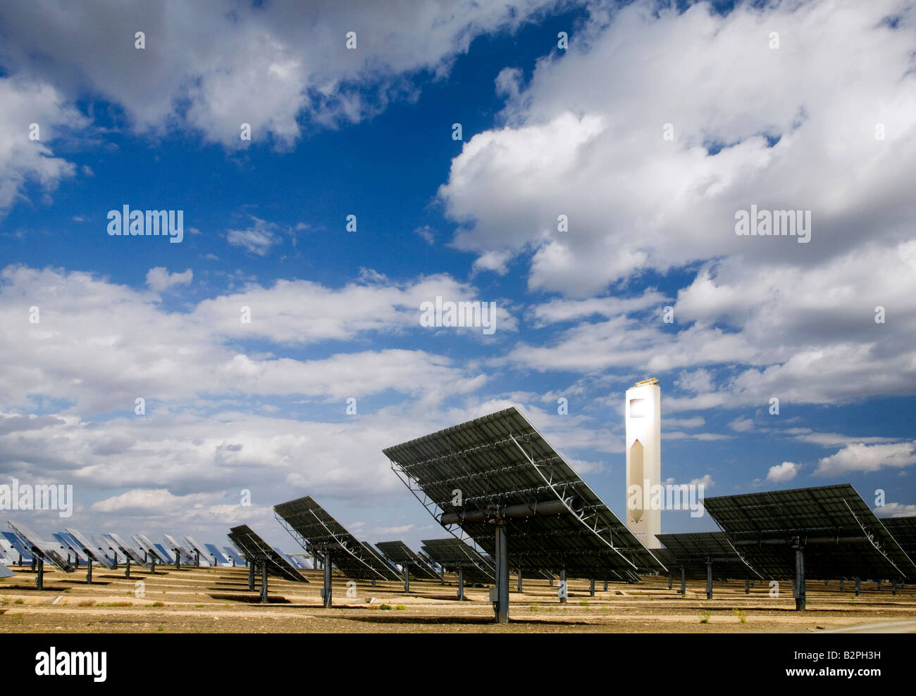 A field of mirrors concentrate solar energy on to a solar tower, near ...
