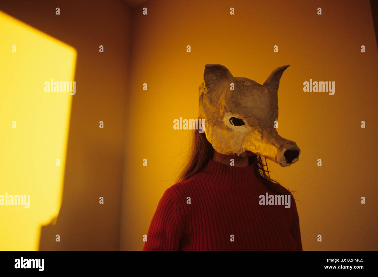 Portrait of teen girl wearing a wolf mask inside a house Stock Photo