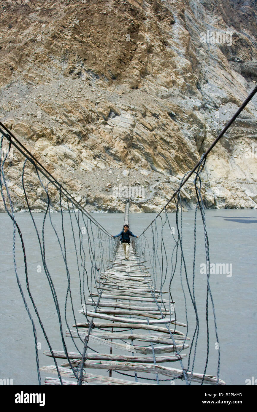 Hiker Crossing a Suspension Bridge Near Passu in Hunza Valley in