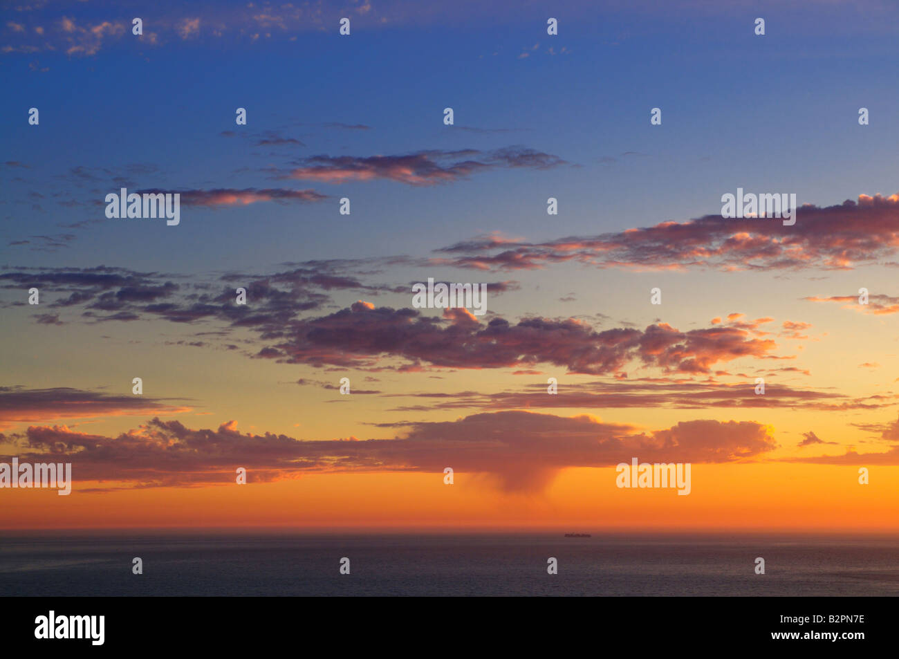 Majestic sunset over Pacific Ocean with a silhouette of a lonely ship ...