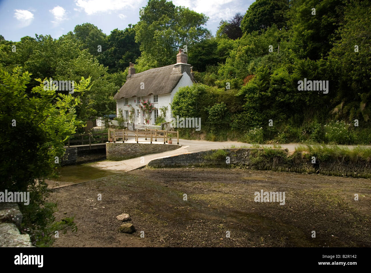 A chocolate box country cottage thatched home at Helford, England, UK Stock Photo
