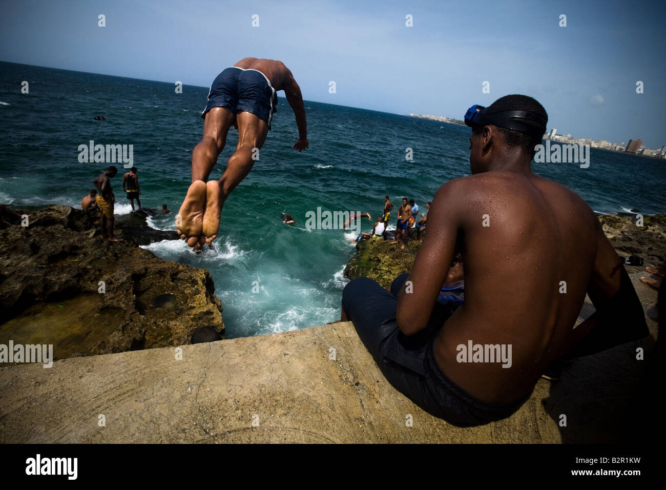 A teenager jumps off a concrete wall into the ocean along the Malecon avenue in Havana Cuba on Saturday June 28 2008 Stock Photo