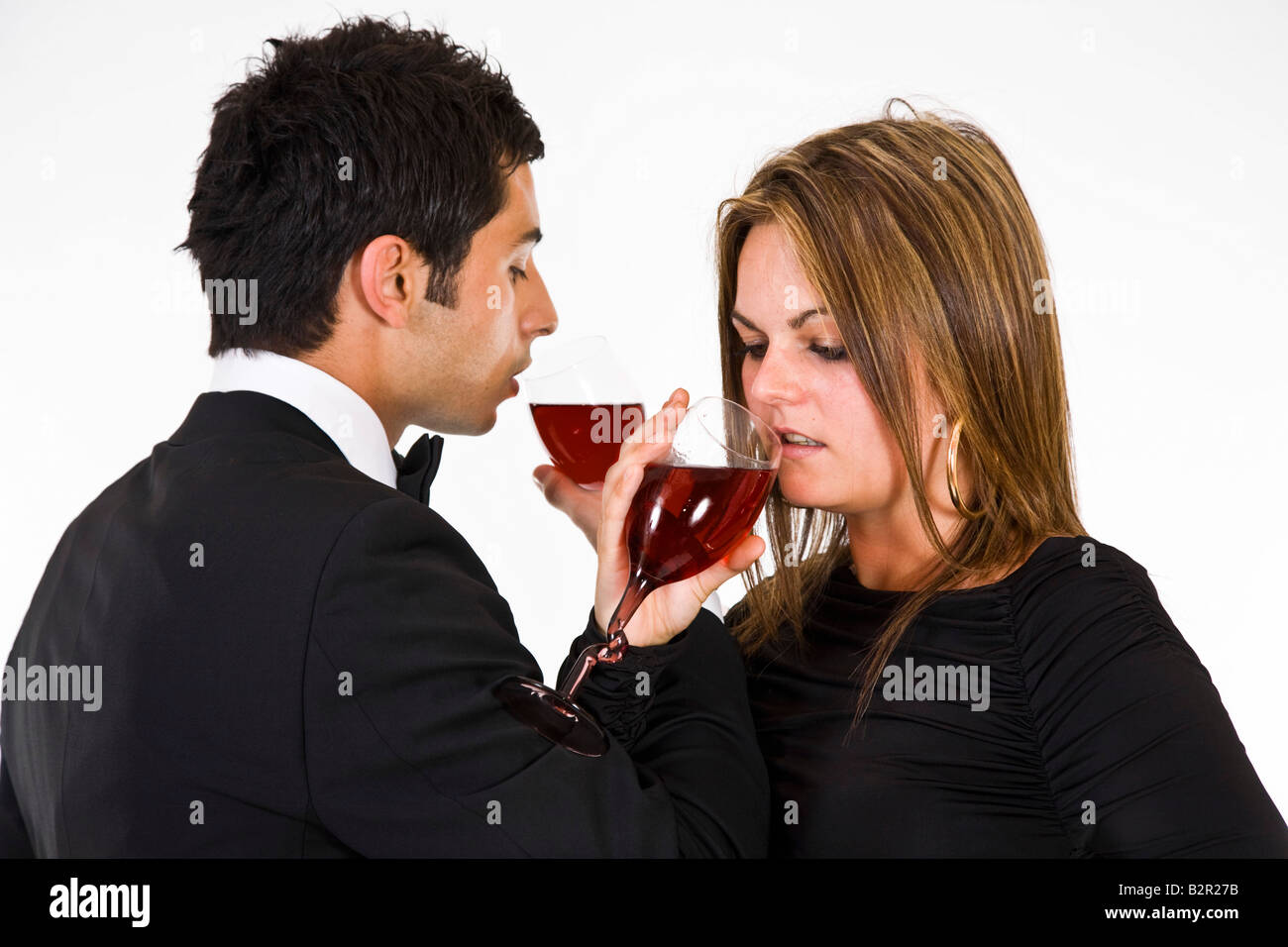 Young couple in evening wear drinking red wine Stock Photo - Alamy