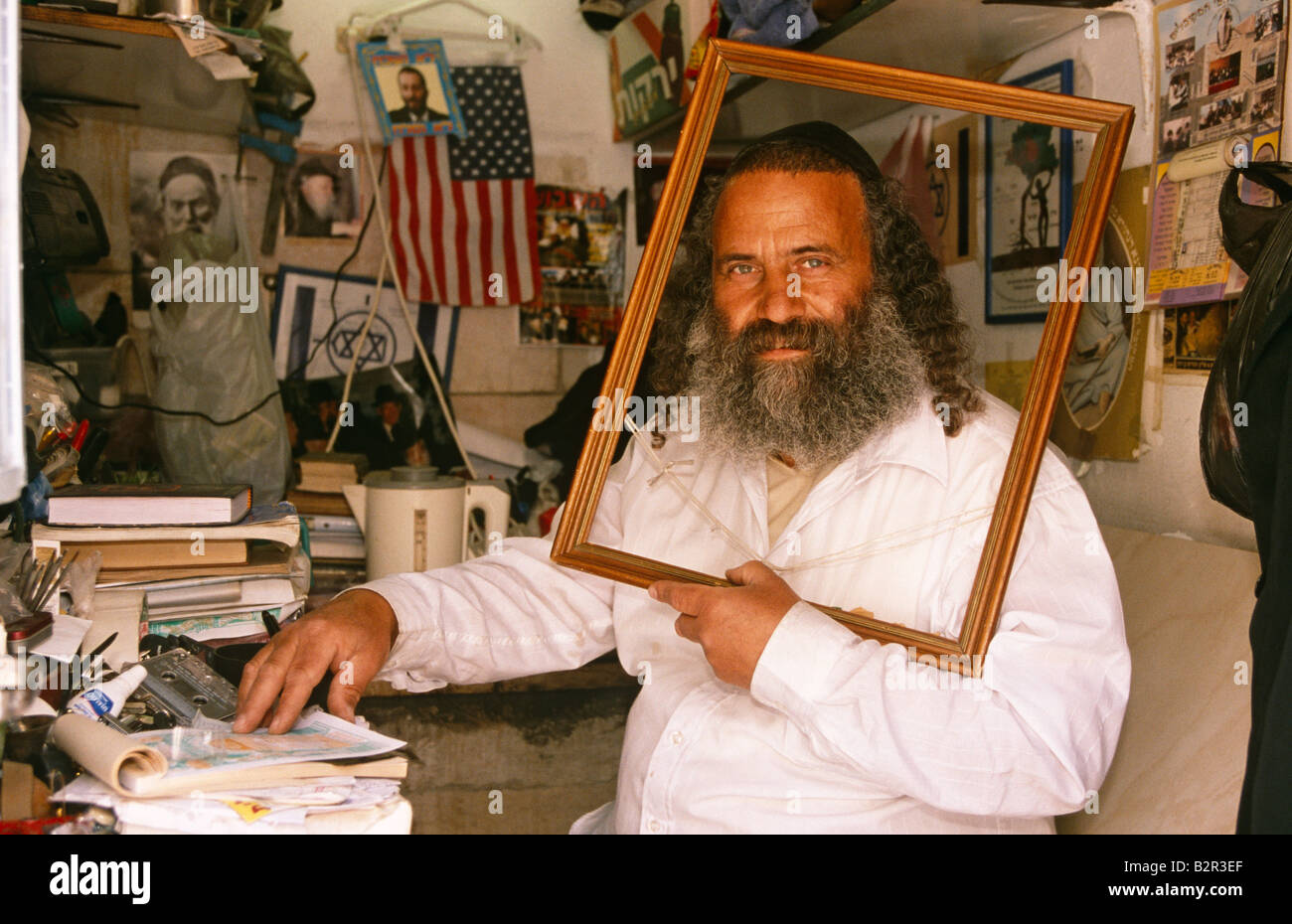 Male shopkeeper framing his head and shoulder portrait within picture frame, Israel, Middle East Stock Photo