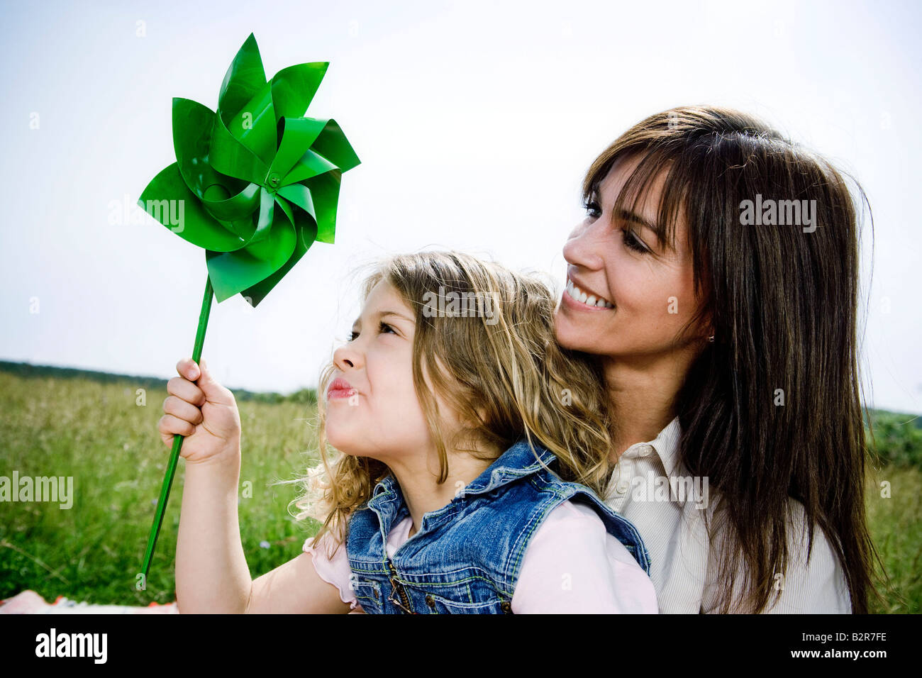 Woman and girl with toy windmill Stock Photo
