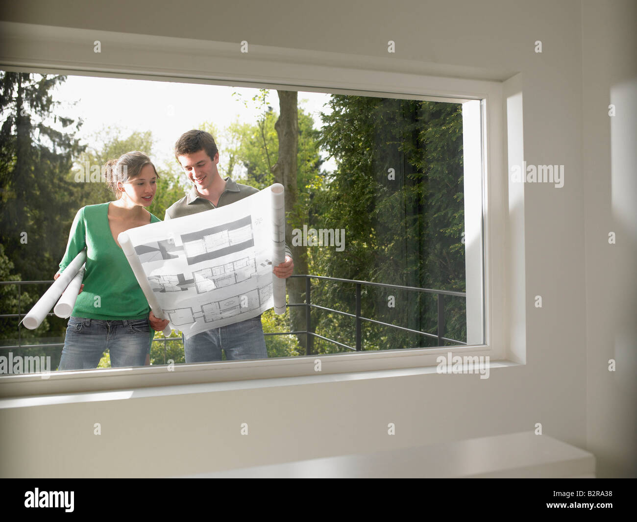 Couple with blueprint, outdoors Stock Photo