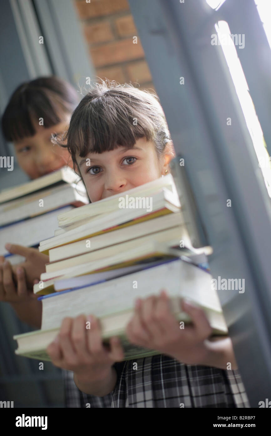 School girls holding stacks of books Stock Photo - Alamy