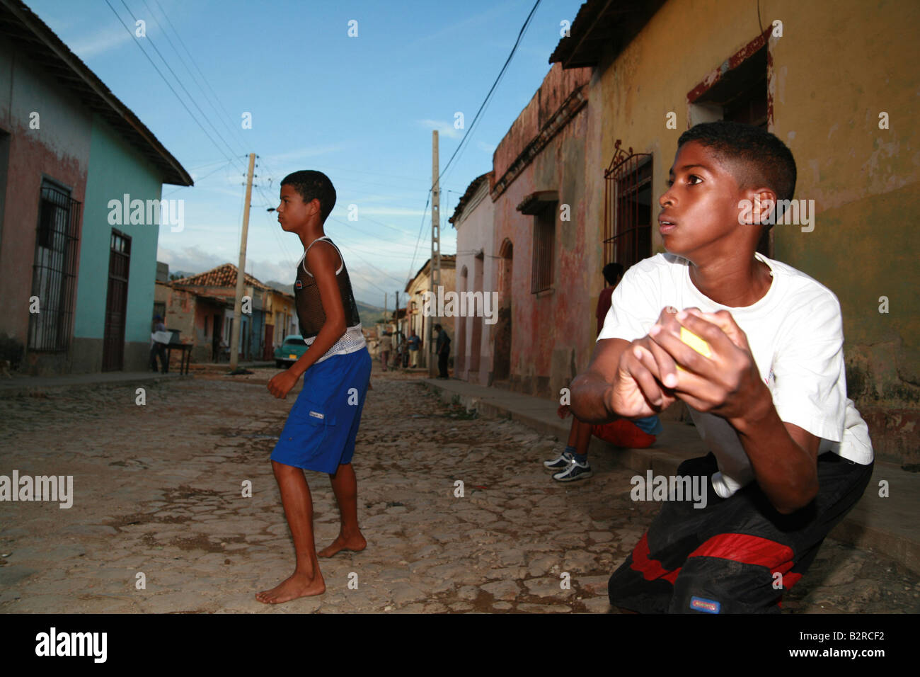 Children playing baseball on a street in Trinidad Sancti Spíritus Province Cuba Latin America Stock Photo