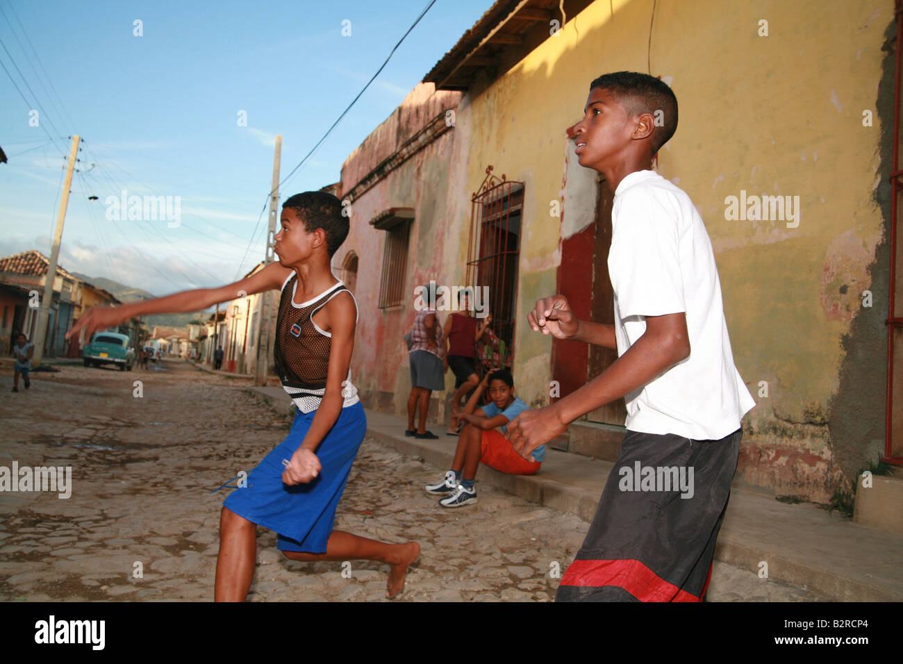 Children playing baseball on a street in Trinidad Sancti Spíritus Province Cuba Latin America Stock Photo