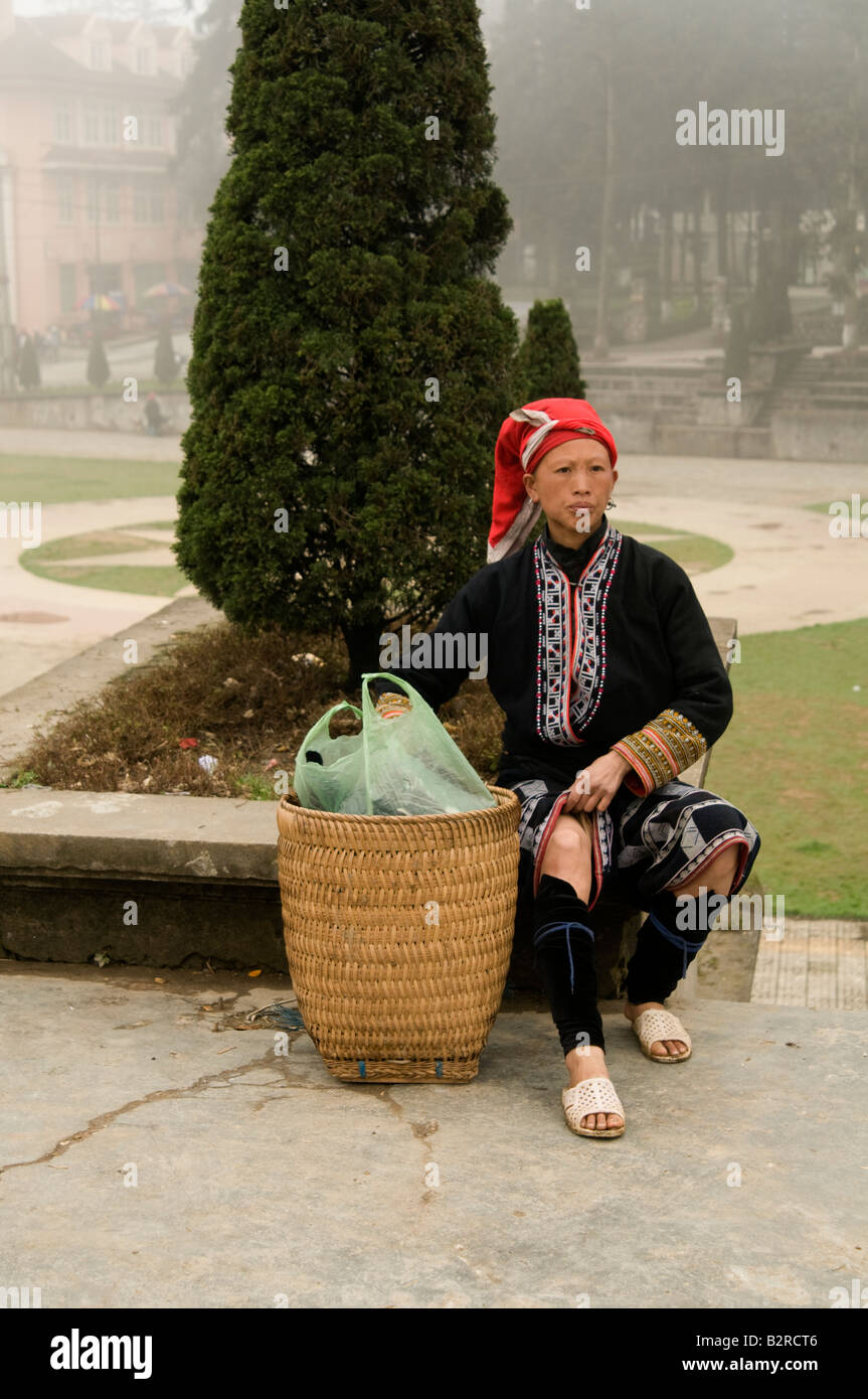 A full length shot of a Red Dao tribal girl sitting alone in Sapa Vietnam Stock Photo