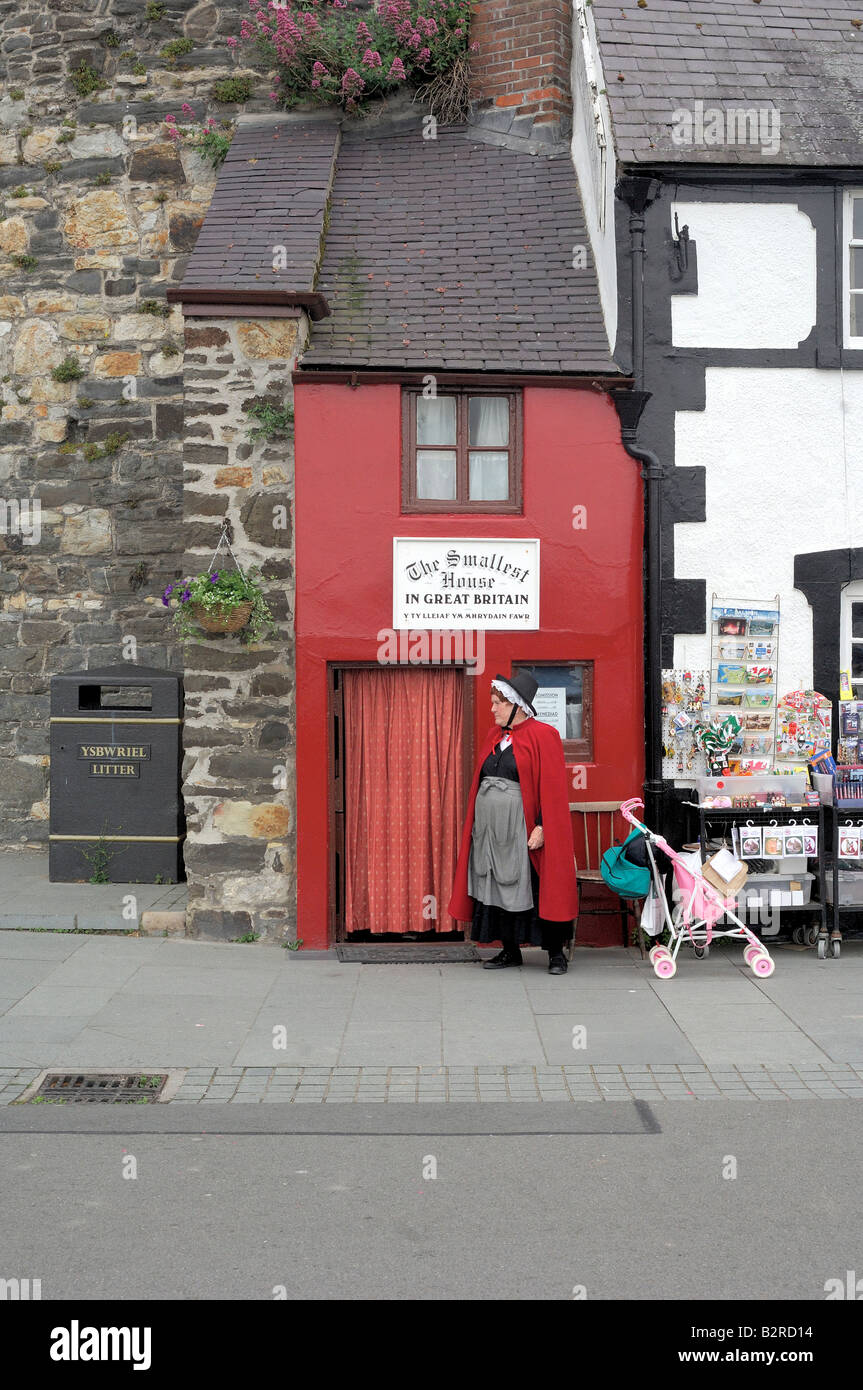 The smallest house in Great Britain in Conwy North Wales with lady dressed in traditional Welsh national costume outside Stock Photo