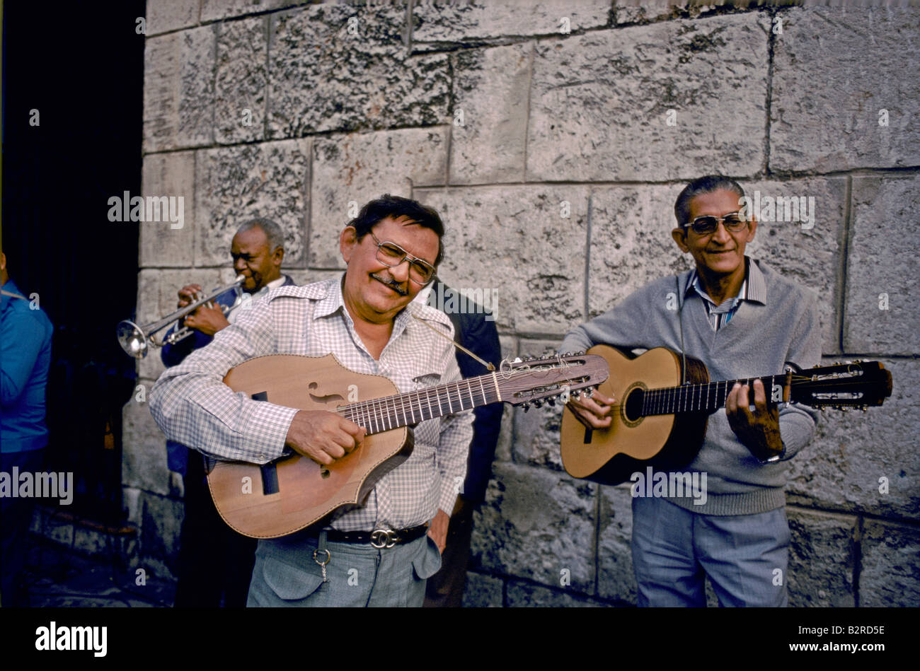 A group of male musicians on guitars and trumpet, wearing glasses and smiling, Old Town, Havana, Cuba Stock Photo
