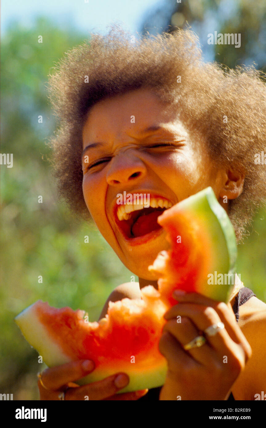 child laughing eating water melon kleinmond township cape province Stock Photo