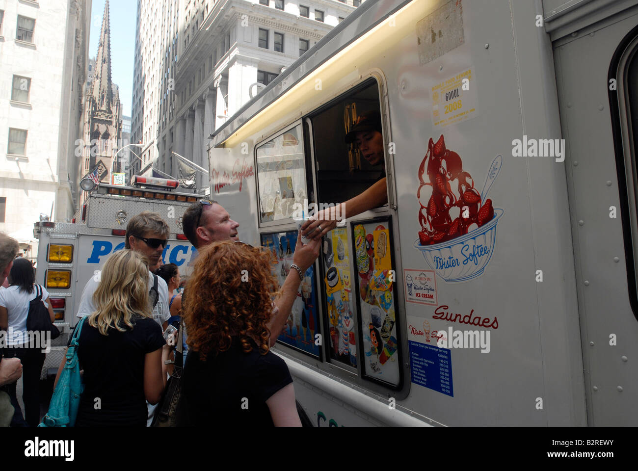 Ice cream lovers enjoy a cone of soft ice cream from a Mr Softee truck on Wall Street in New York Stock Photo