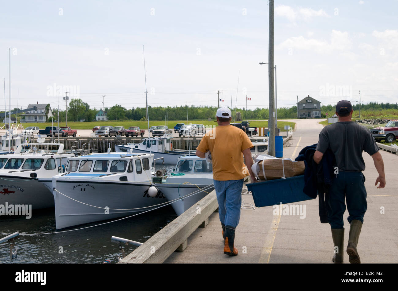 Escuminac Wharf with fishermen unloading lobster traps in New Brunswick Stock Photo