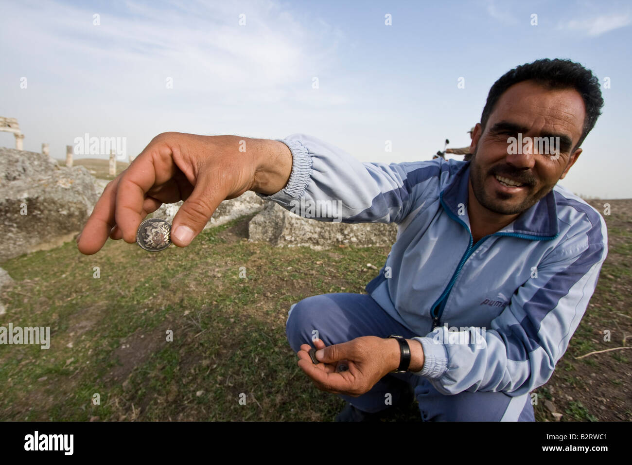 Man Selling Fake Ancient Roman Coins at the Roman Runis of Apamea in Syria Stock Photo