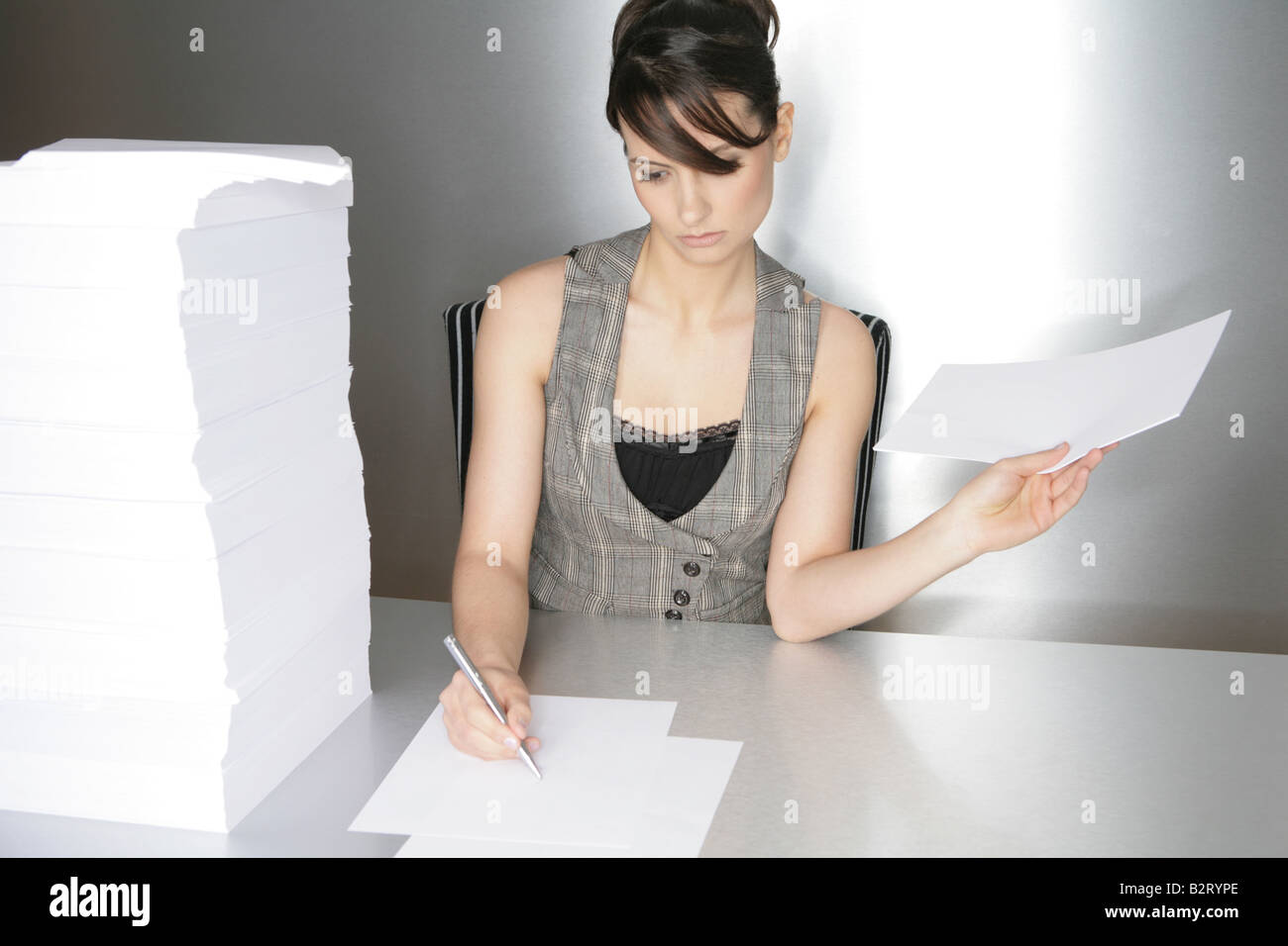 Businesswoman aged 24 taking notes on a silver desktop Stock Photo