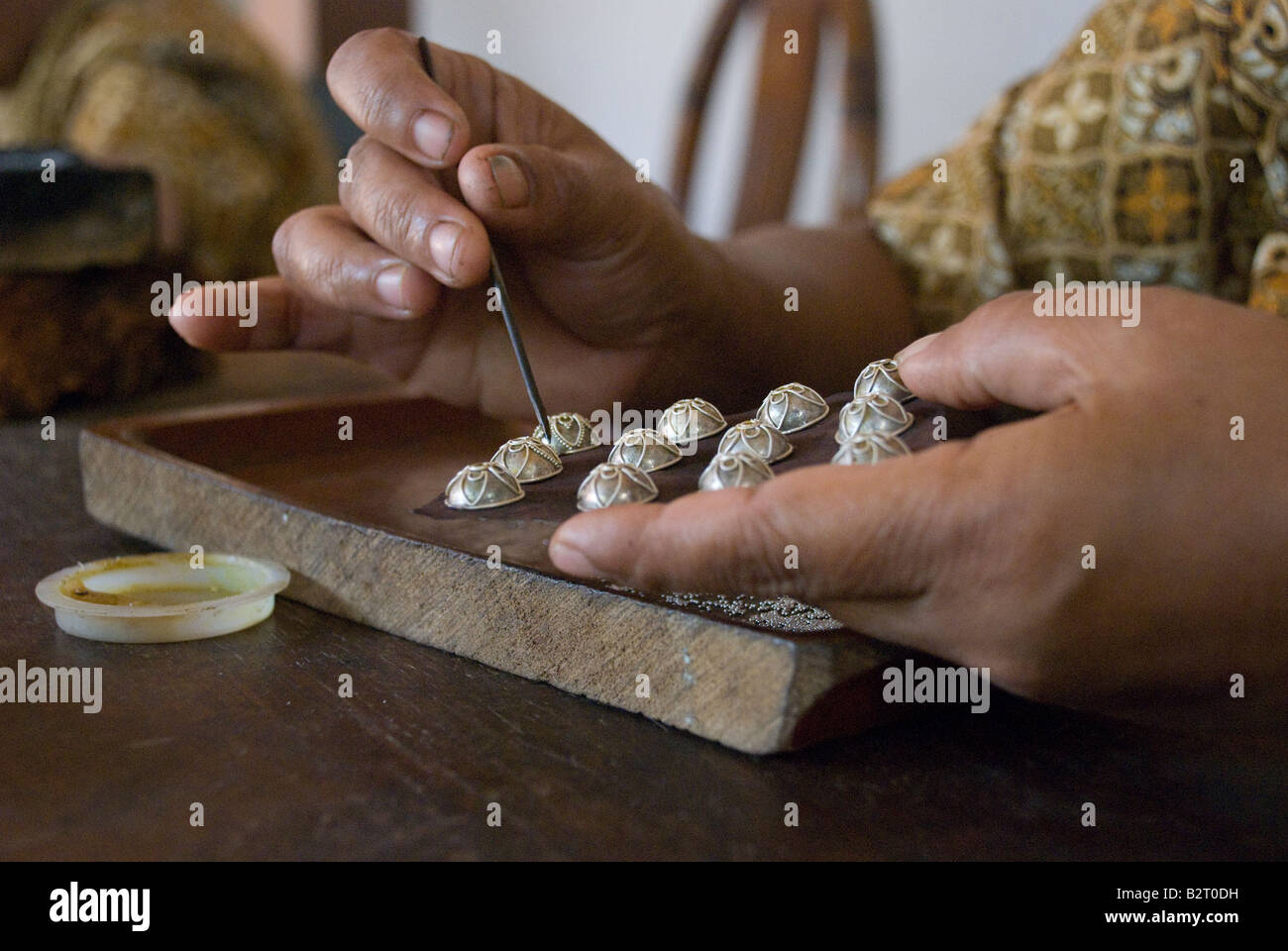 silver dragon ornament bali indonesia hand made silversmith craft metal ornate detail decorate fine wood hands fingers indonesia Stock Photo