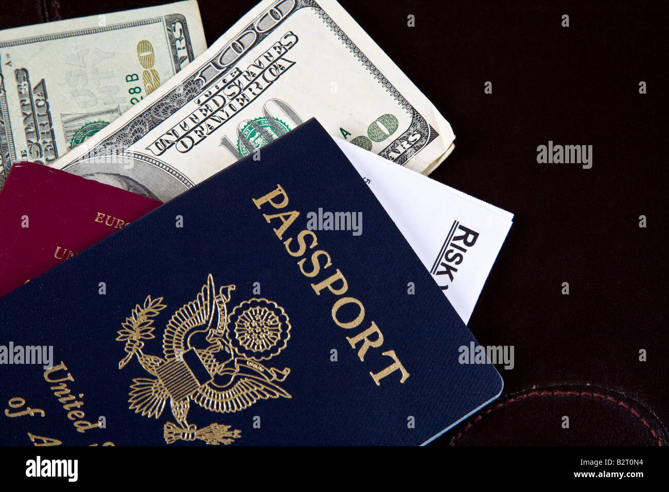 USA and British passports with US dollars protruding and card with risk Stock Photo