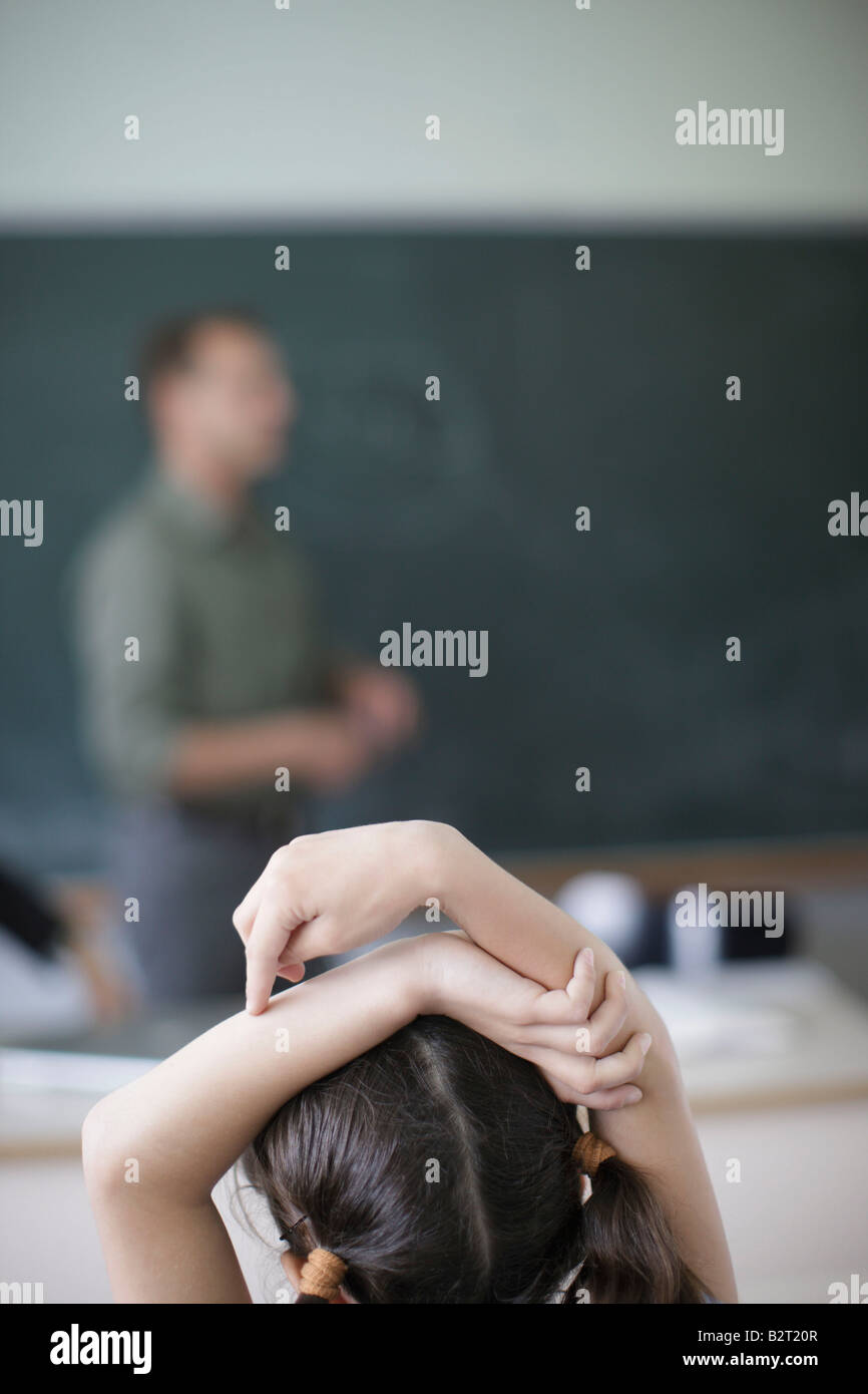 School Girl Raising Hands In Class Stock Photo Alamy