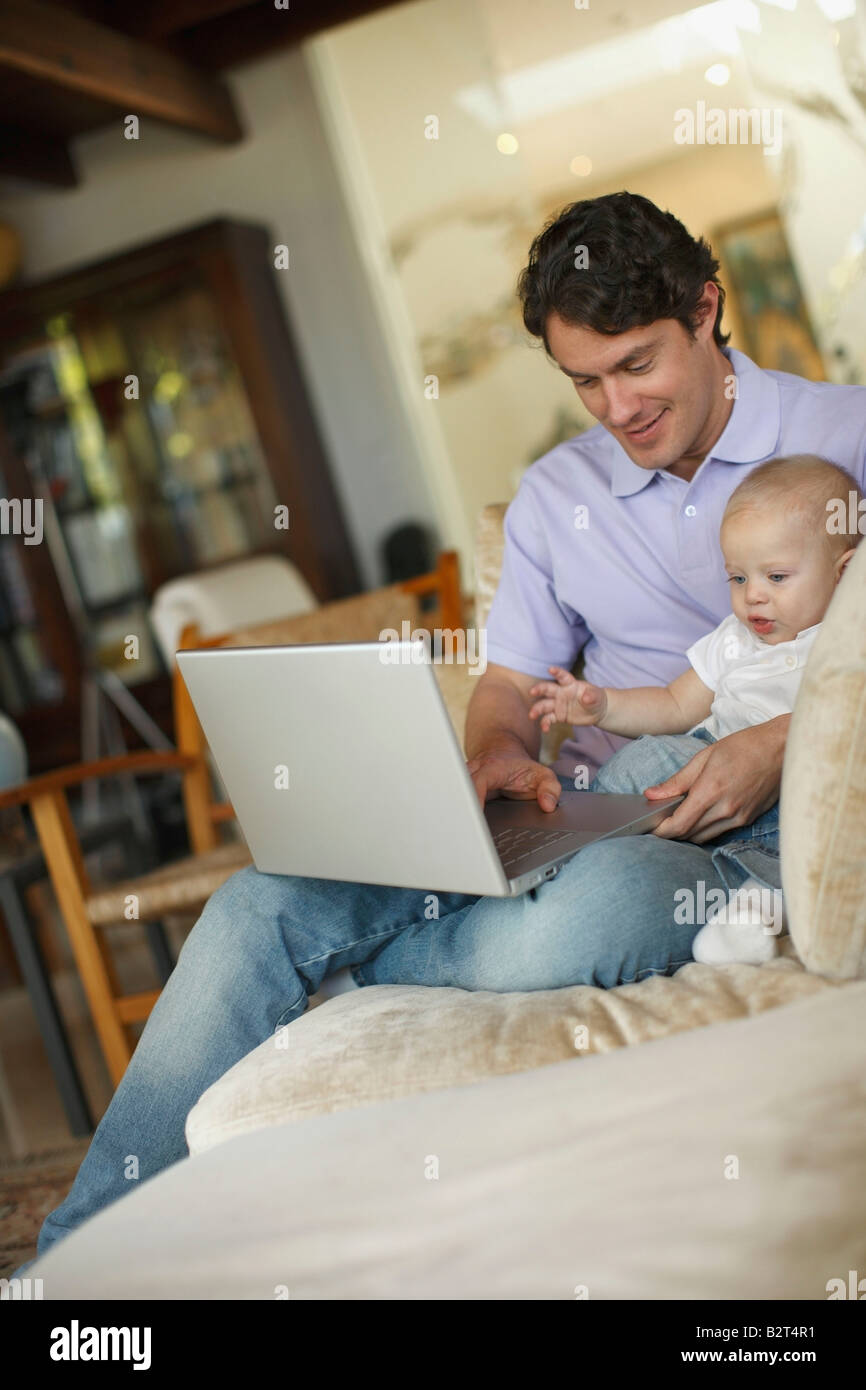 Father sitting at laptop with young son Stock Photo - Alamy