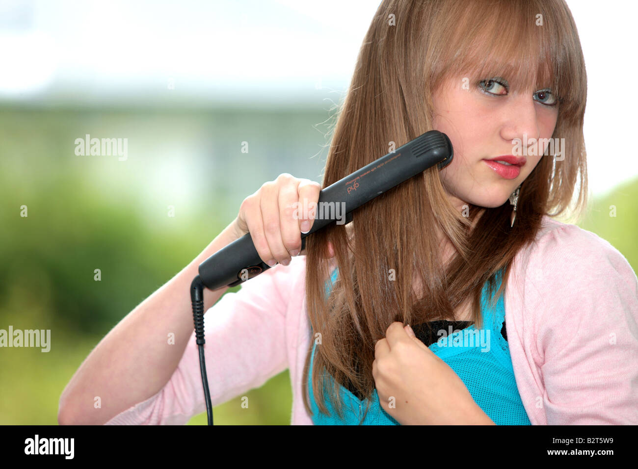Teenage Girl Straightening Hair Model Released Stock Photo