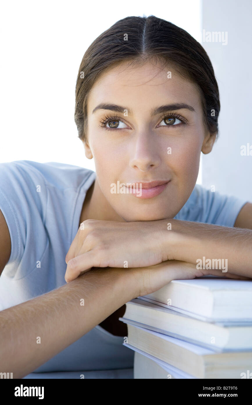 Woman resting head on arms on top of stack of books Stock Photo Alamy