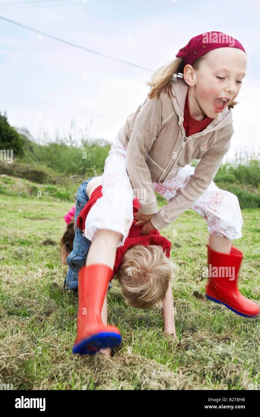 Two children playing leapfrog Stock Photo